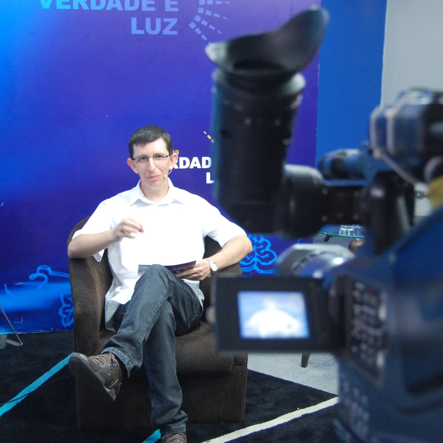 Andre em gravação do programa Verdade e Luz, com o livro na mão